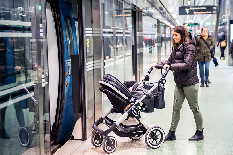 Resenär med barnvagn går på tåg
