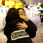Representant från Stockholms stadsmission skänker en kram