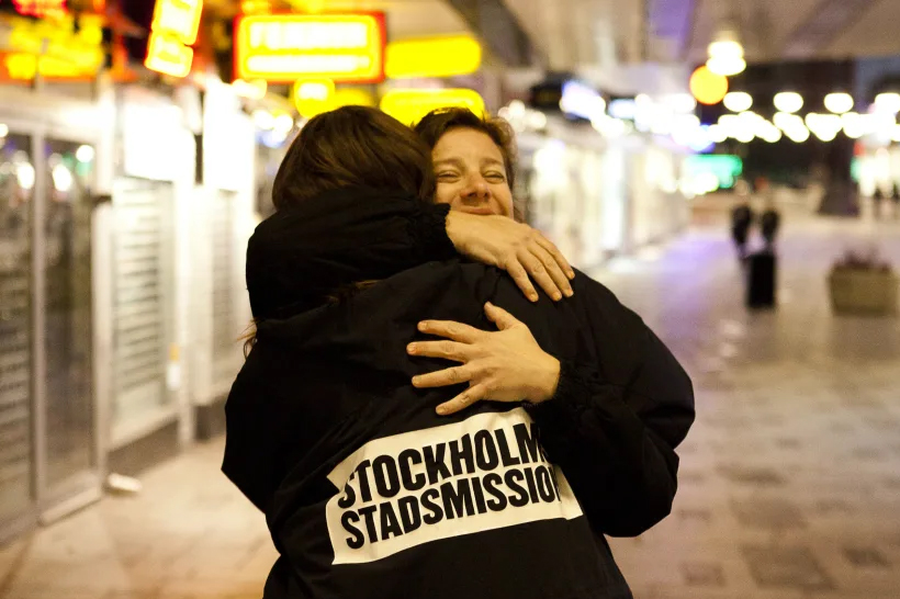 Representant från Stockholms stadsmission skänker en kram